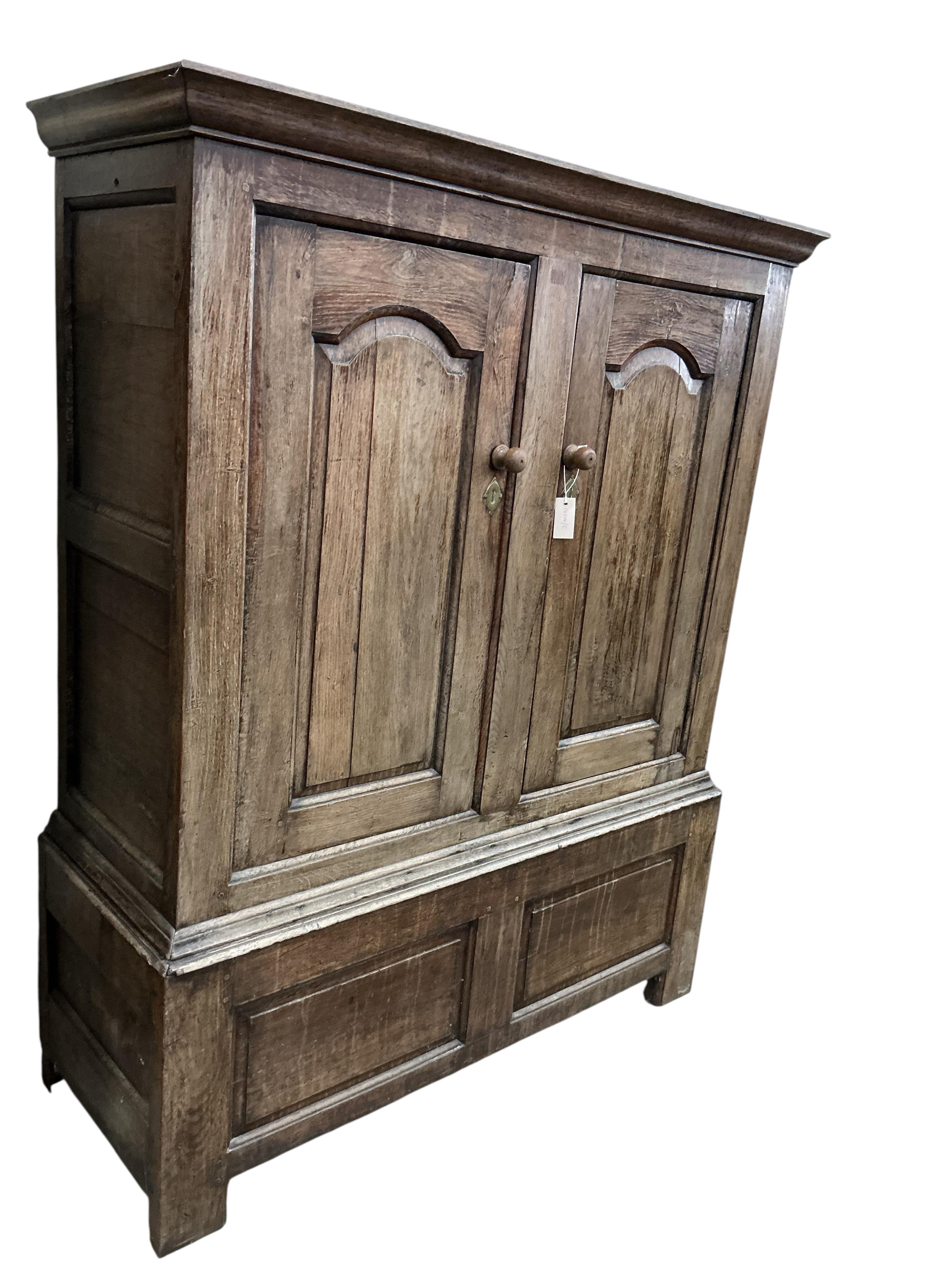 An 18th century oak hanging cupboard, width 131cm, depth 49cm, height 165cm